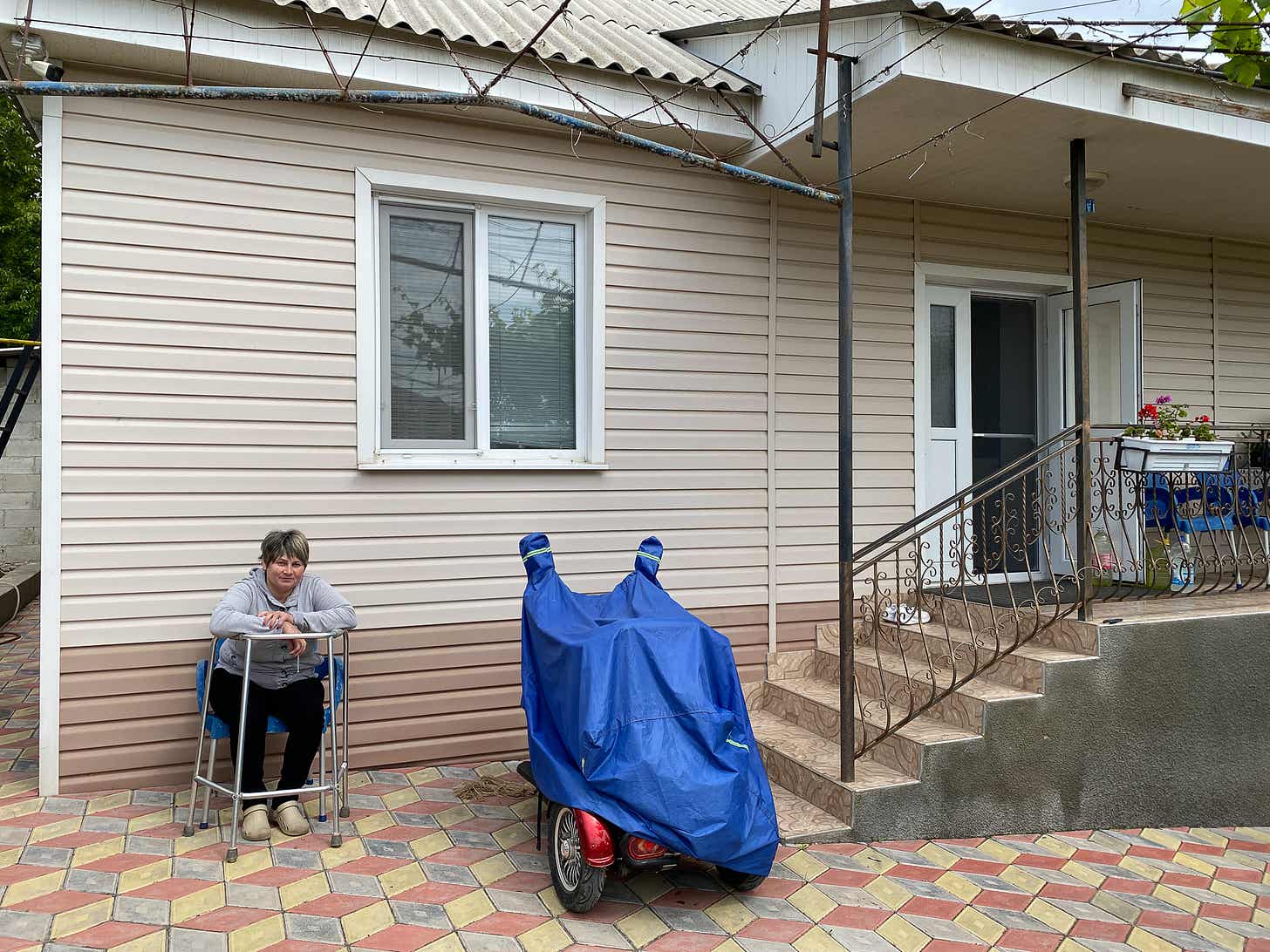 Lilia Caraman, 55 de ani, casnică. Se află în fața casei ei, unde așteaptă cu nerăbdare ca cineva să-i deschidă poarta.
