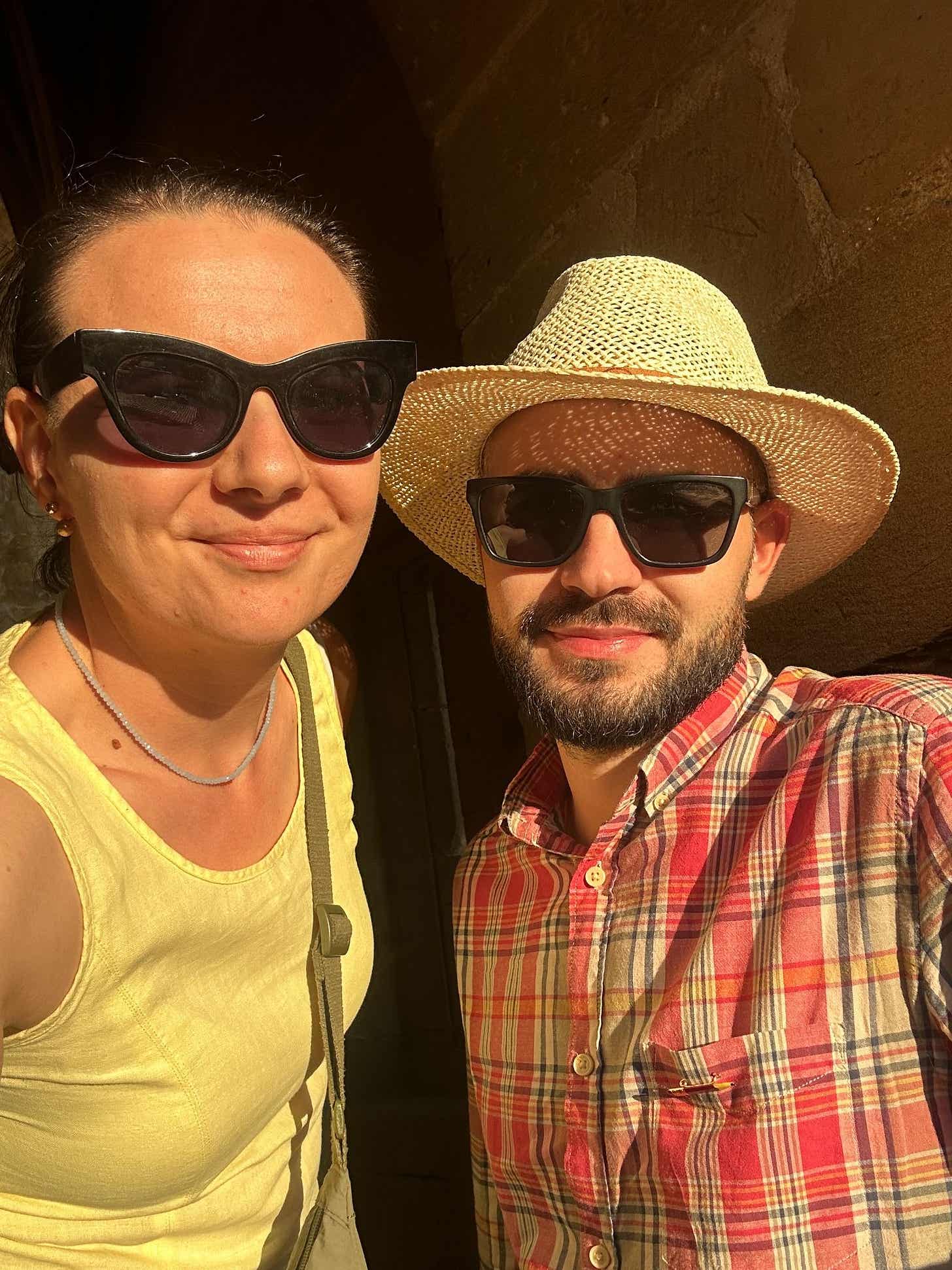 Nicoleta Felea și Ionuț Teoderașcu fac un selfie la apus, lângă zidul de piatră al bisericii din satul Ujué